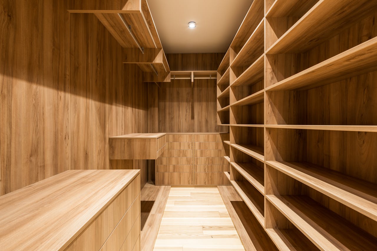Creative design of wooden wardrobe with empty shelves and parquet under shiny lamp in house